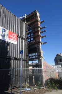 Building facade in downtown Christchurch propped up by stacked containers