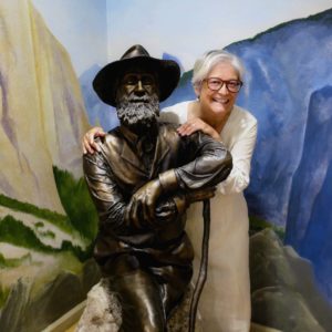 dawn bazely with the statue of John Muir at the Muir homestead in california